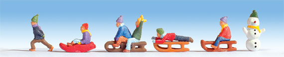 Bambini sulla neve con slittini